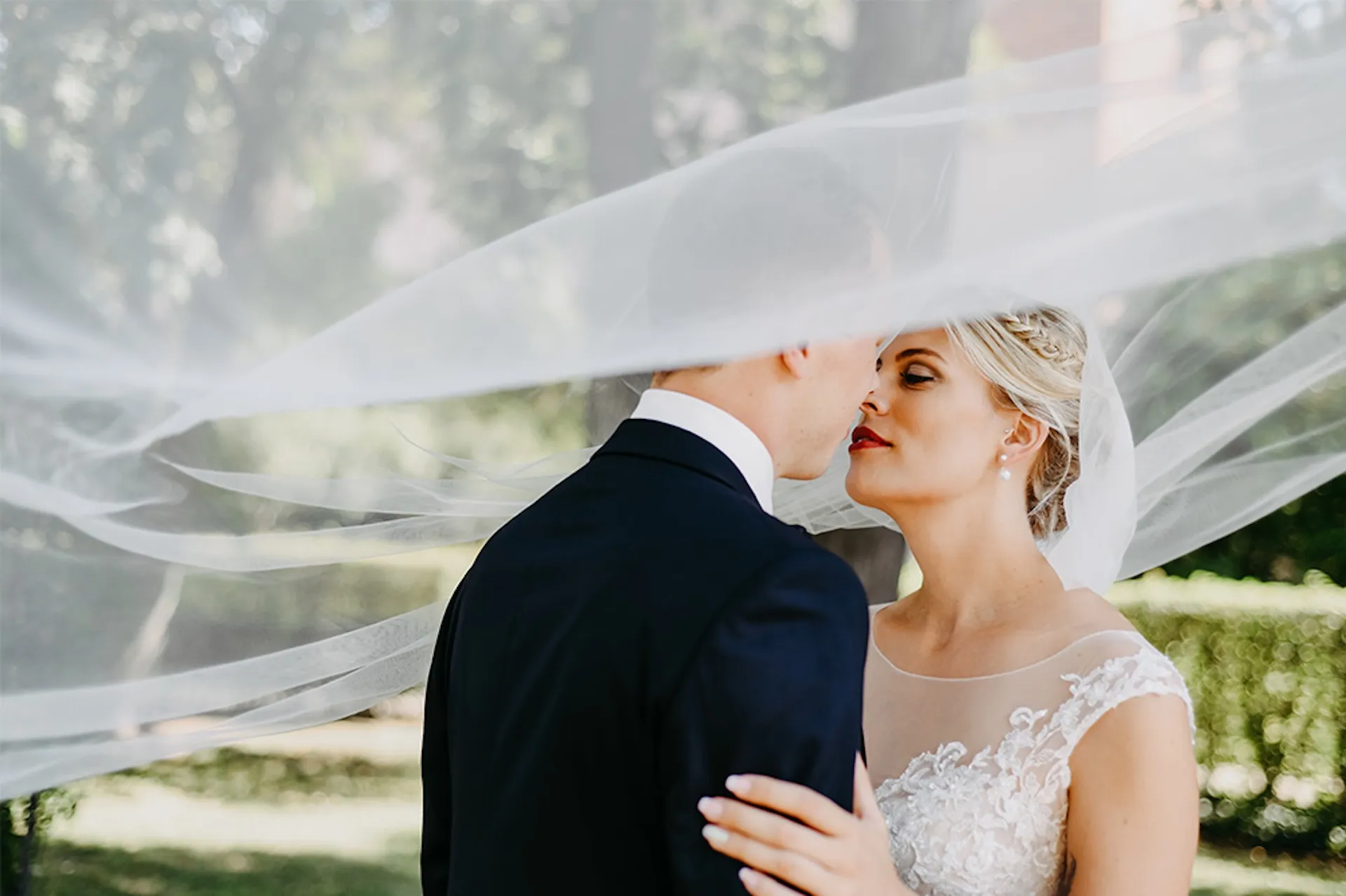 Brautpaar küsst sich unter Schleier