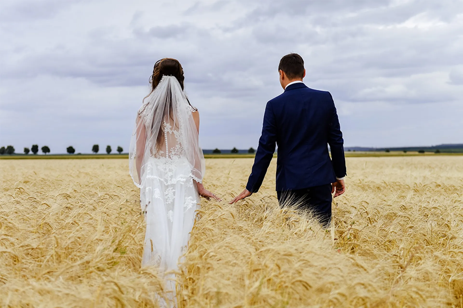 Brautpaar läuft durch Kornfeld