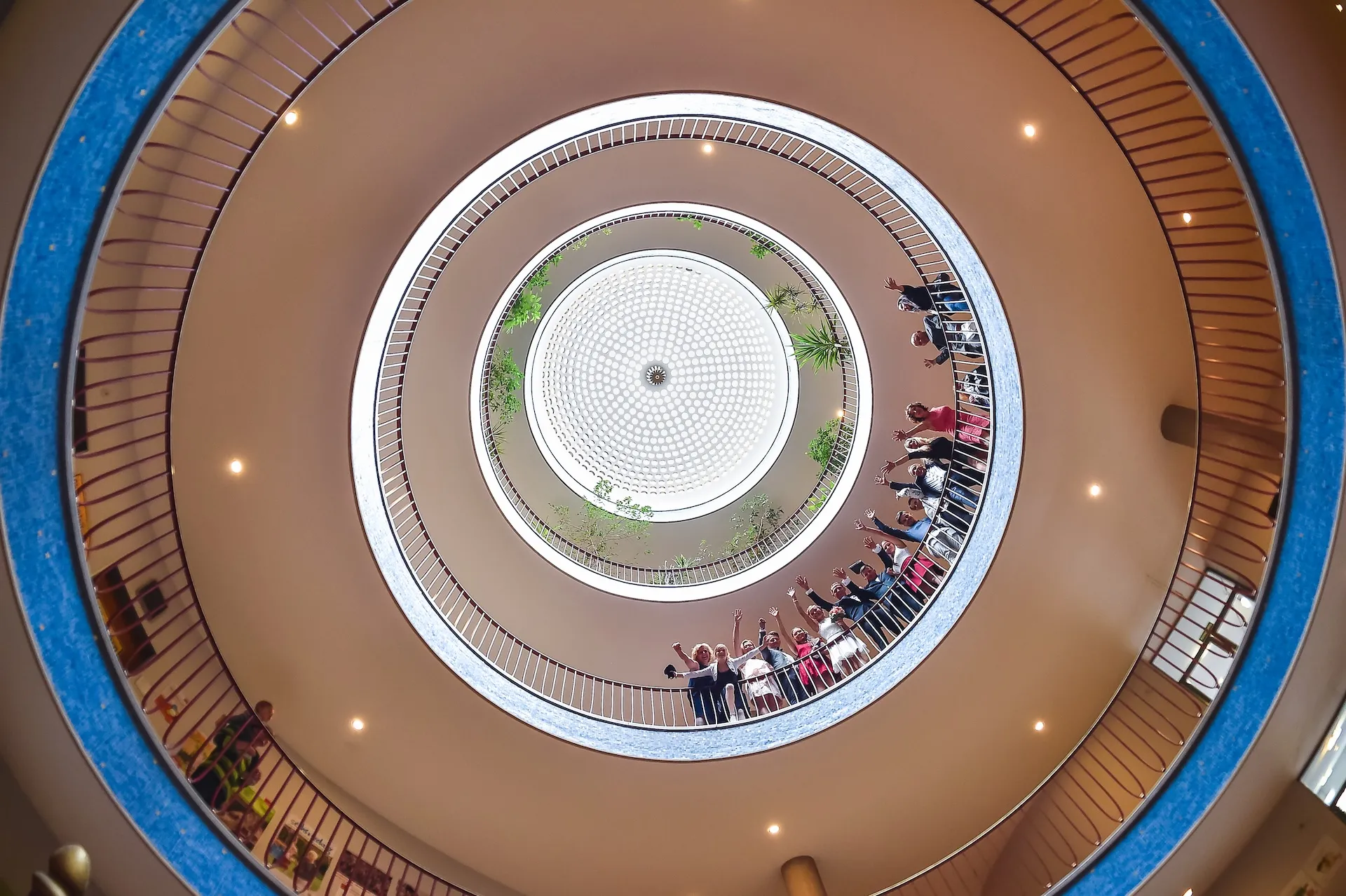 Hochzeitsgesellschaft blickt vom Atrium herab